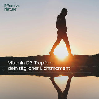Silhouette eines gehenden Mannes vor Sonnenuntergang mit Spiegelung im Wasser, Text: Vitamin D3 Tropfen – dein täglicher...