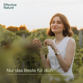 Frau hält Weintrauben in einem Weinberg bei Sonnenuntergang – Effective Nature, Nur das Beste für dich