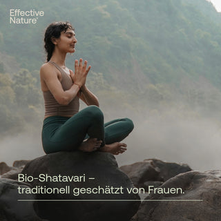 Frau meditiert in Lotusposition auf Felsen in nebeliger Berglandschaft, Bio-Shatavari von Effective Nature