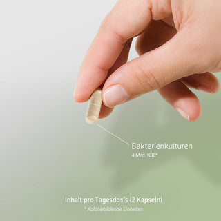 Hand hält eine Kapsel mit Bakterienkulturen, 4 Mrd. KBE, Tagesdosis 2 Kapseln, heller Hintergrund