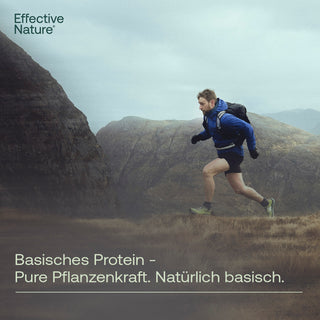 Mann läuft im Gebirge, blaue Jacke, Rucksack – Effective Nature Basisches Protein, Pure Pflanzenkraft