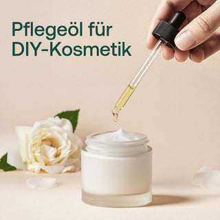 Pipette mit gelbem Pflegeöl wird in weiße Creme getropft, daneben weiße Rose, Text: Pflegeöl für DIY-Kosmetik