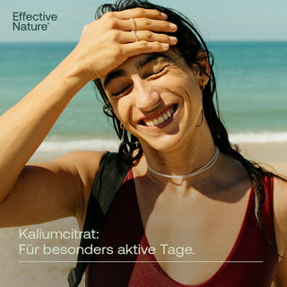 Lächelnde Frau am Strand mit nassen Haaren, Effective Nature Kaliumcitrat – Für besonders aktive Tage